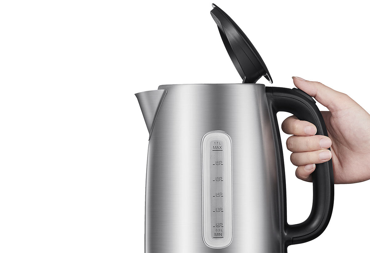 Ένα χέρι κρατά τον βραστήρα με το καπάκι ανοιχτό.